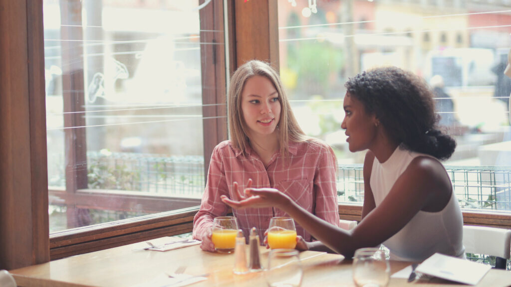 カフェで会話する白人女性と黒人女性